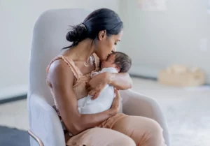 mom kissing little babys forehead