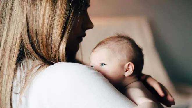 Baby looking away from camera with mothers back to camera