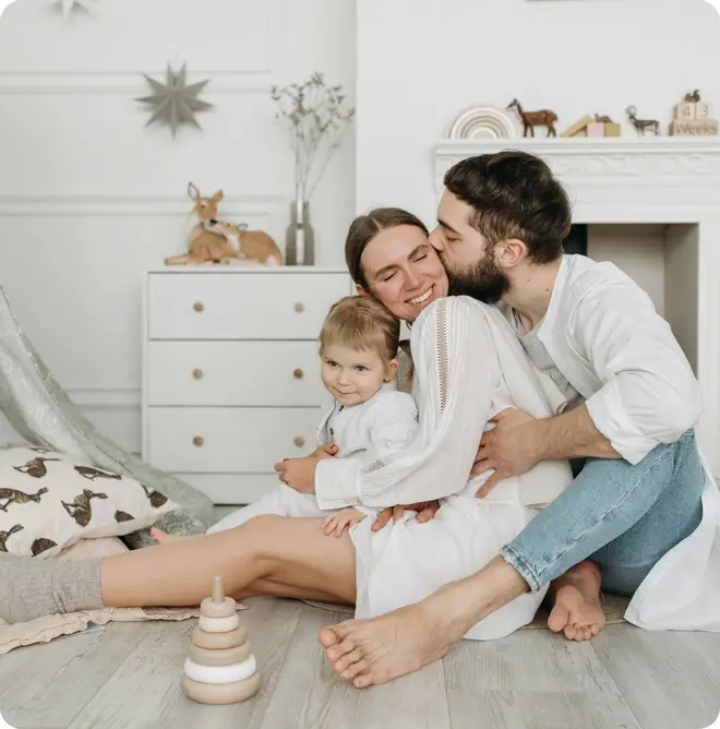 Husband, wife and child in nursery. One happy family.