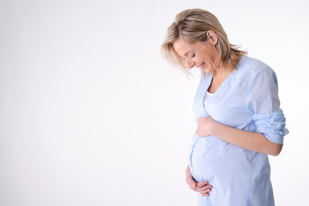 woman holding belly pregnant blank background
