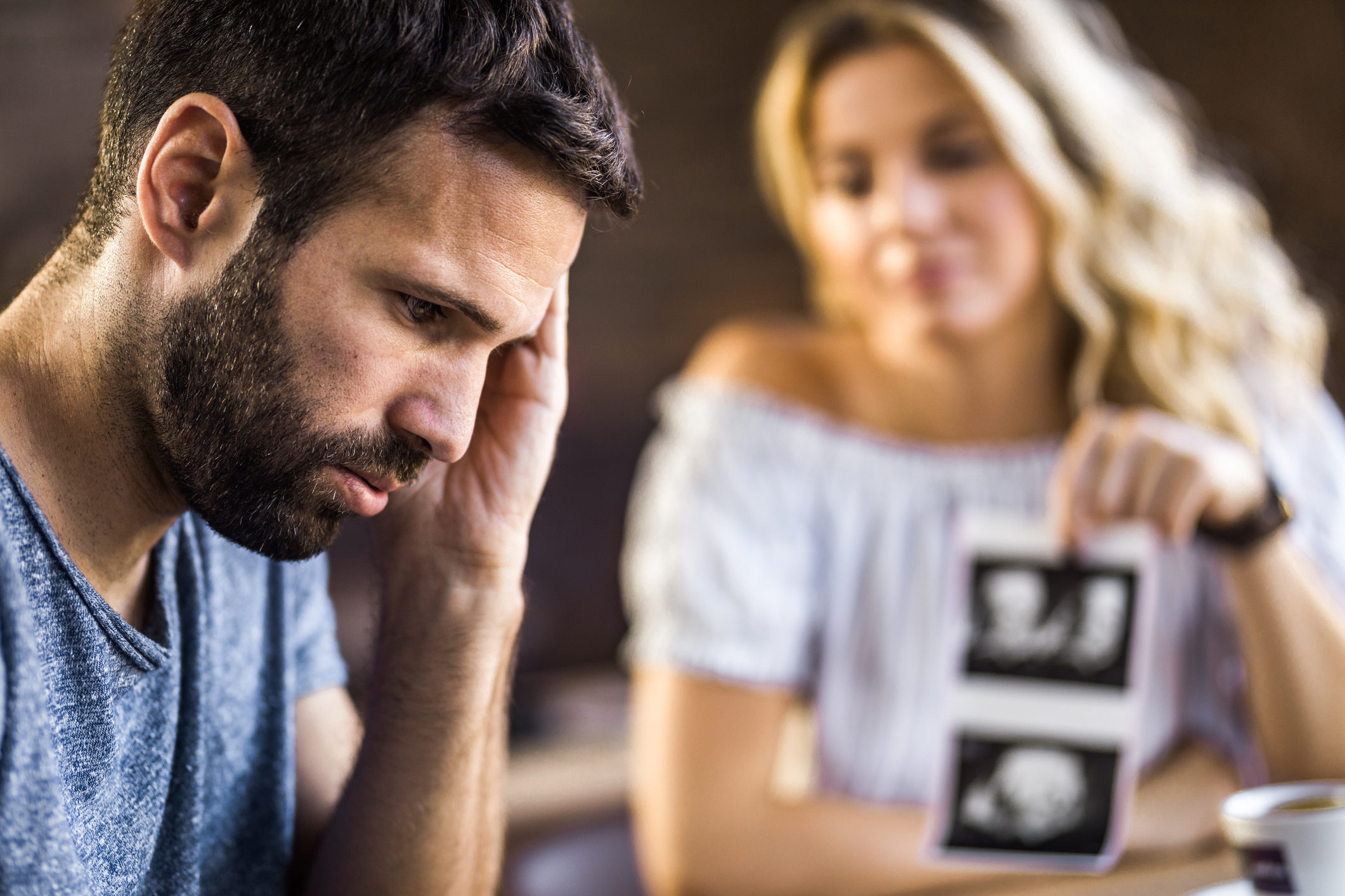 Young man feeling worried after seeing pregnancy scan